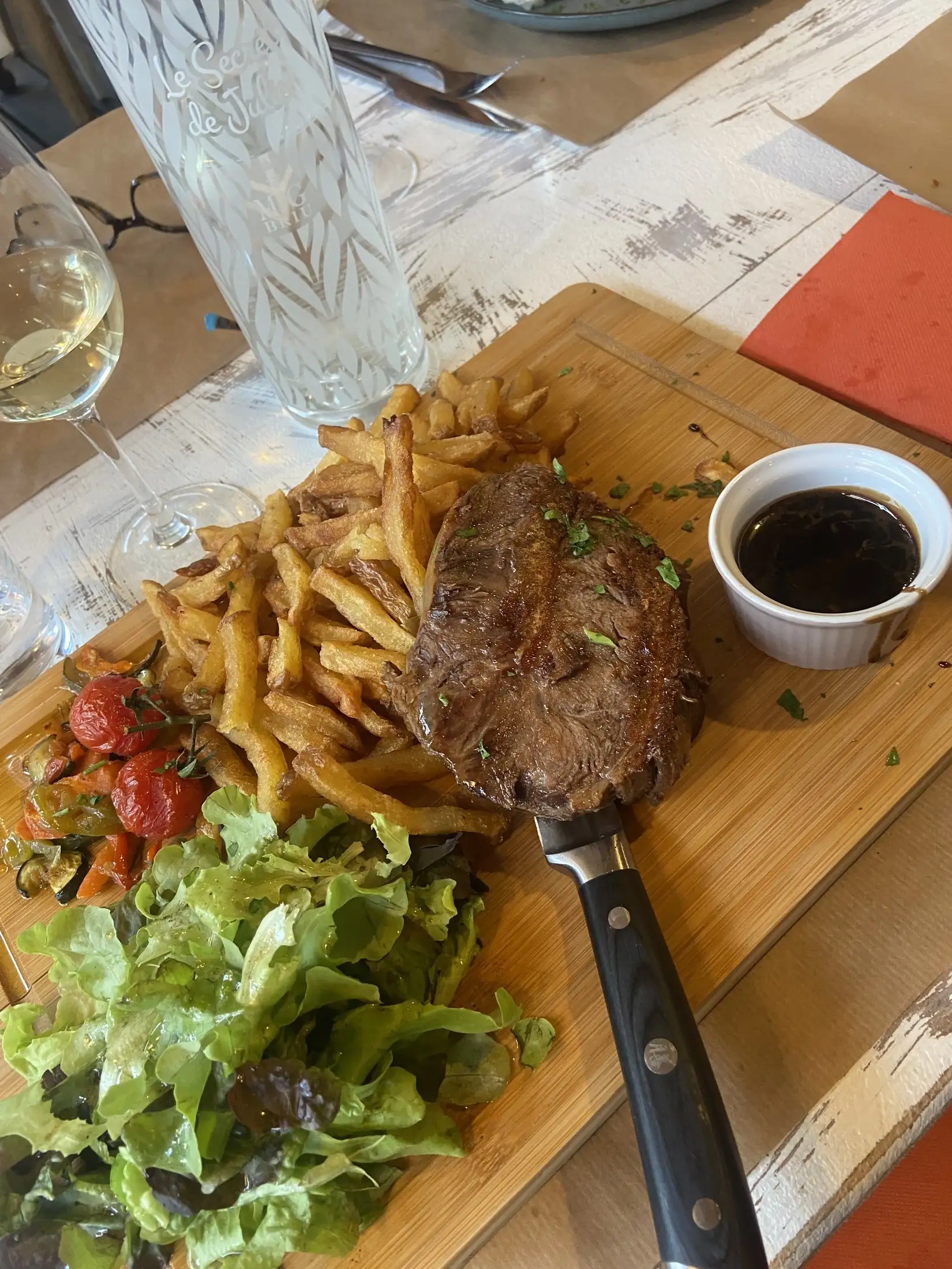 Pièce de viande grillée servie avec frites et salade