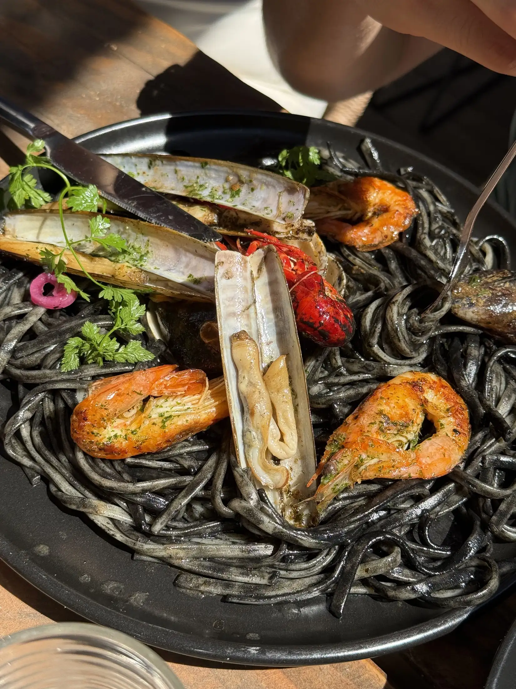 Linguines à l'encre de seiche garnies de coquillages et de crevettes