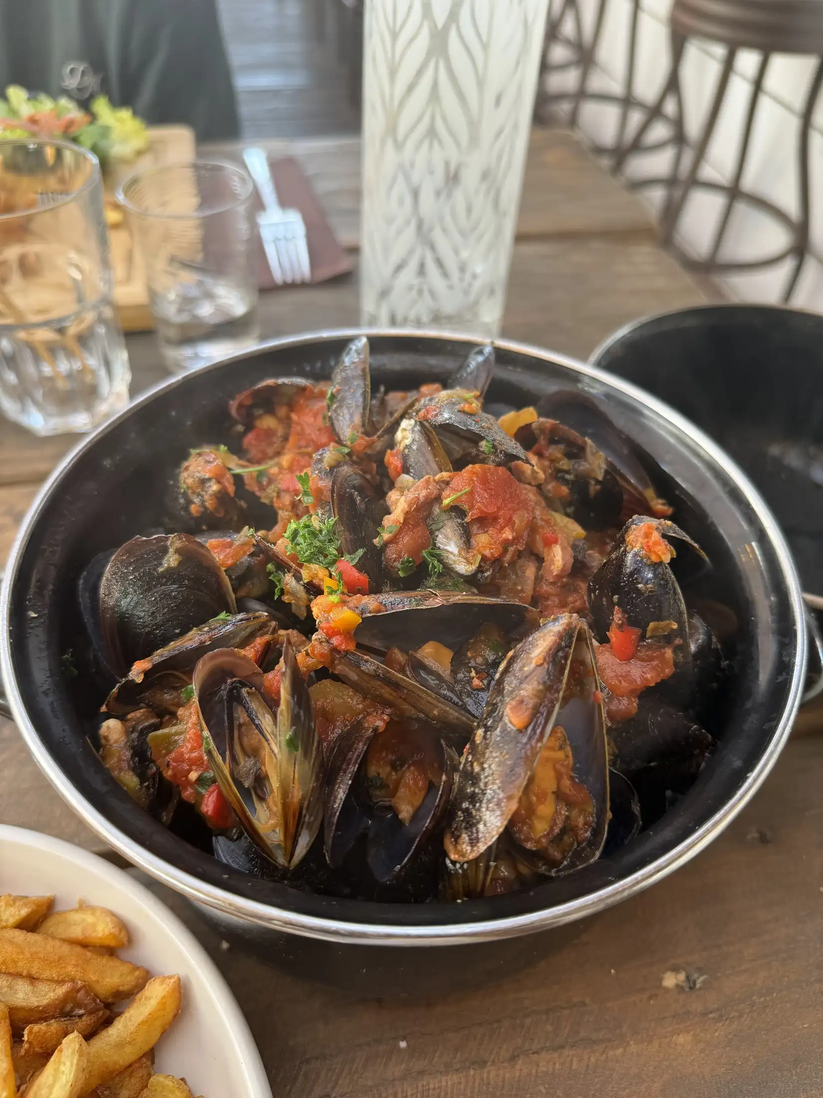 Moules servies en cocotte, accompagnées de frites maison