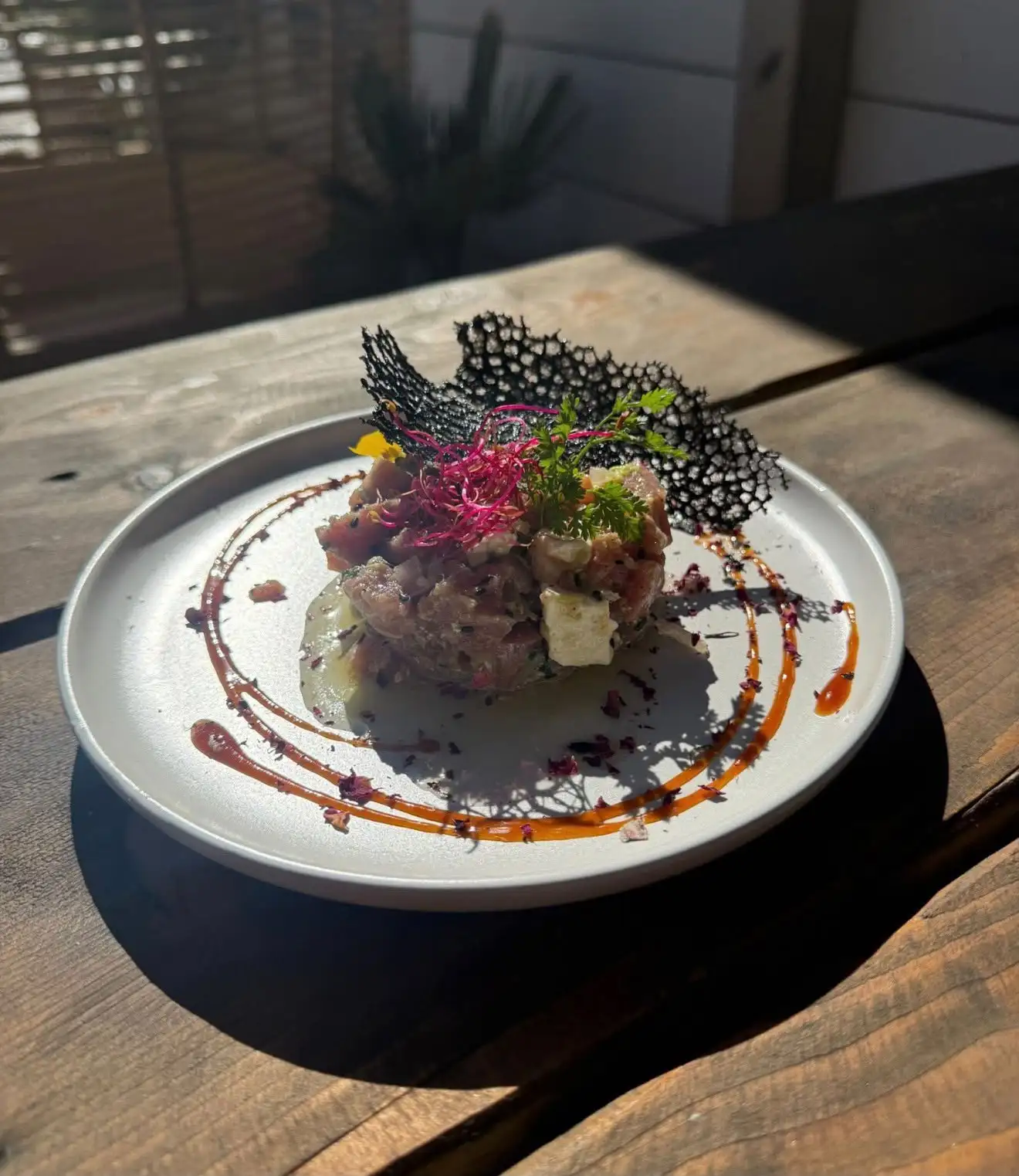 Tartare de thon dressé à l'assiette, avec une tuile croustillante noire
